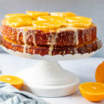 Almond Orange cake on a stand with cut oranges around