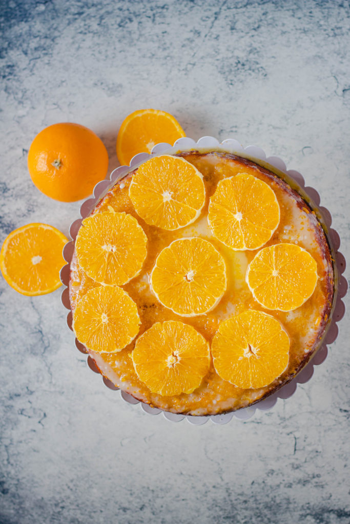 from the top of a Almond Orange cake on a stand with cut oranges around