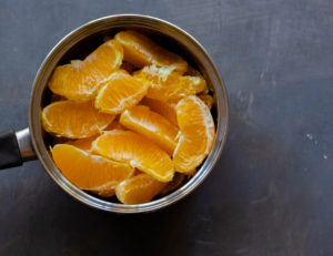 Saucepan with pieces of oranges