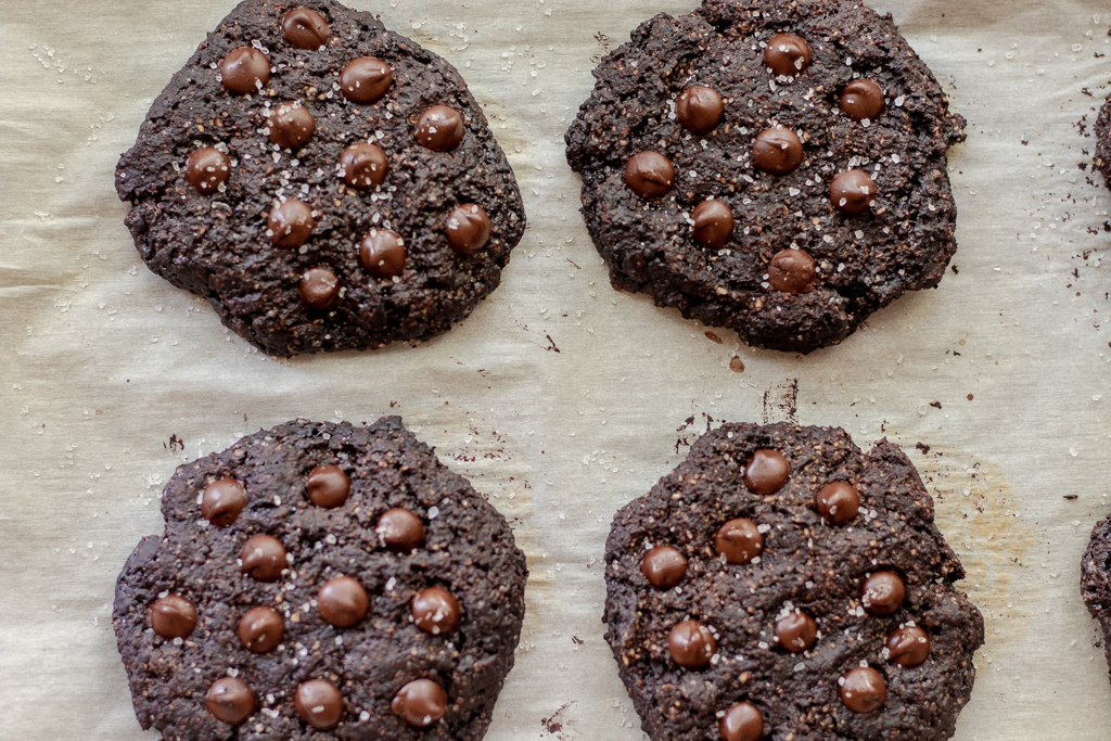 Four Vegan Chocolate Cookies on a cookie sheet lined with parchment paper