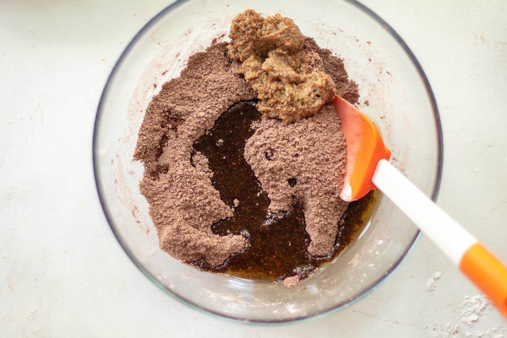 Bowl with flour and sugar and cocoa mixed together and oil and flax eggs added to the mixture