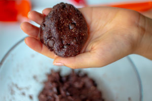 A hand holding molded dough in a cookie shape