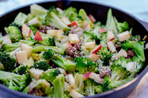 Skillet with beef and broccoli and apples and sesame seeds