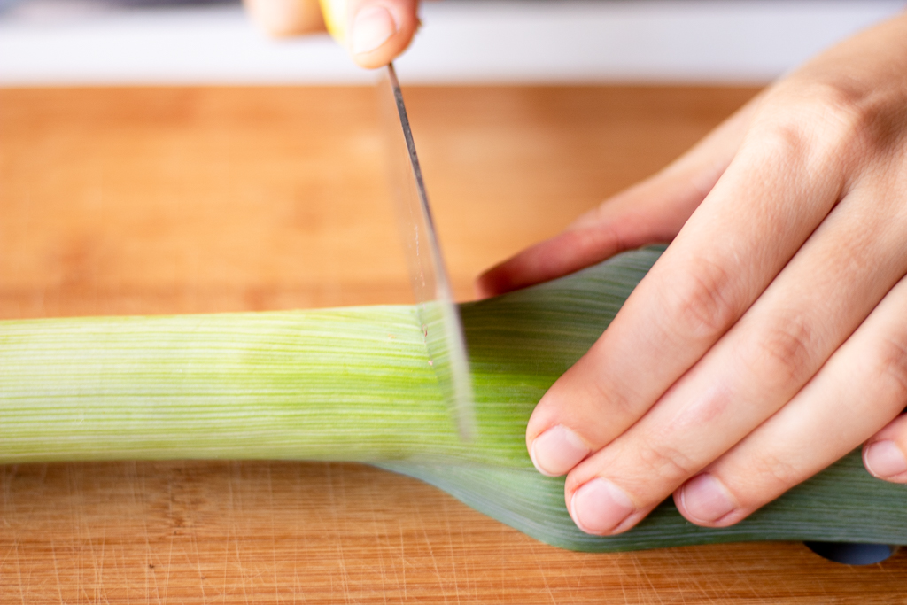 someone cutting a leek