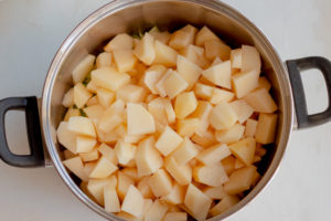 saucepan with white potatoes added to the saute leaks