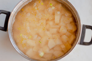 Saucepan with water added to the potatoes and leeks