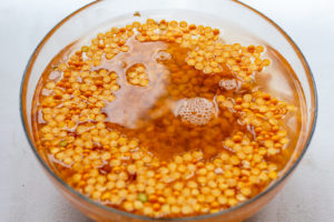 A bowl with yellow split peas soaked in water