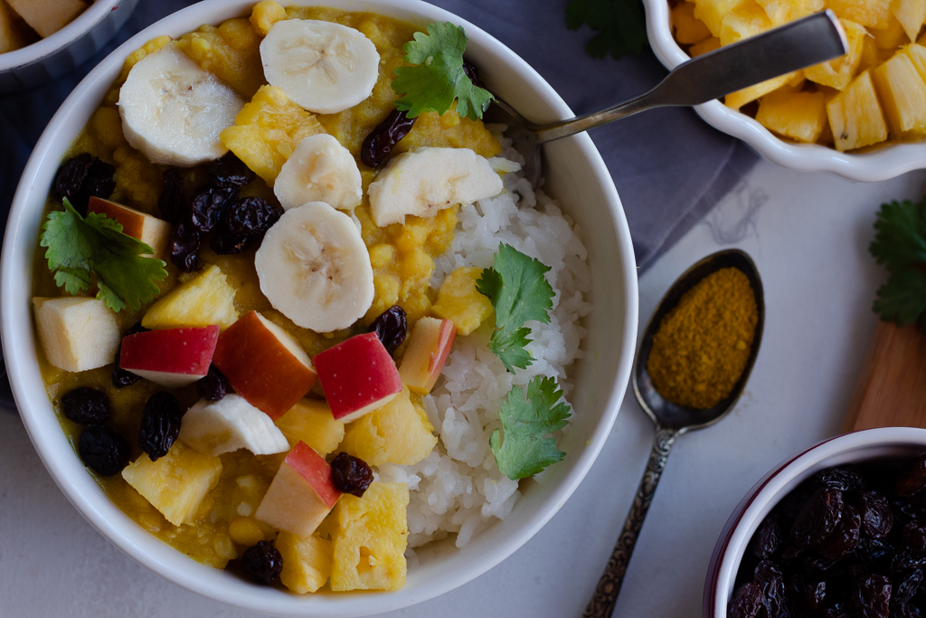 A split pea coconut curry bowl with fruit toppings