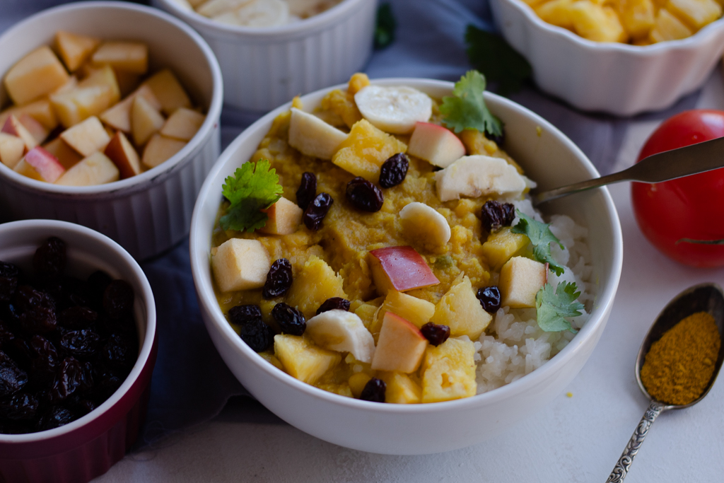 A split pea coconut curry bowl with fruit toppings