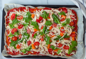 pizza with toppings on it, before being baked