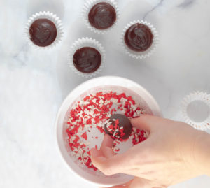 Rolling the vegan chocolate bomb through sprinkles