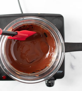 Melted Chocolate in a glass bowl over a pot of water on the stove