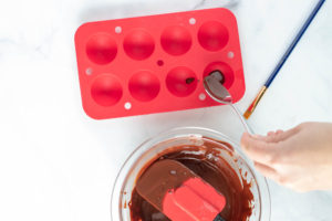 Adding melted chocolate to a silicone mold