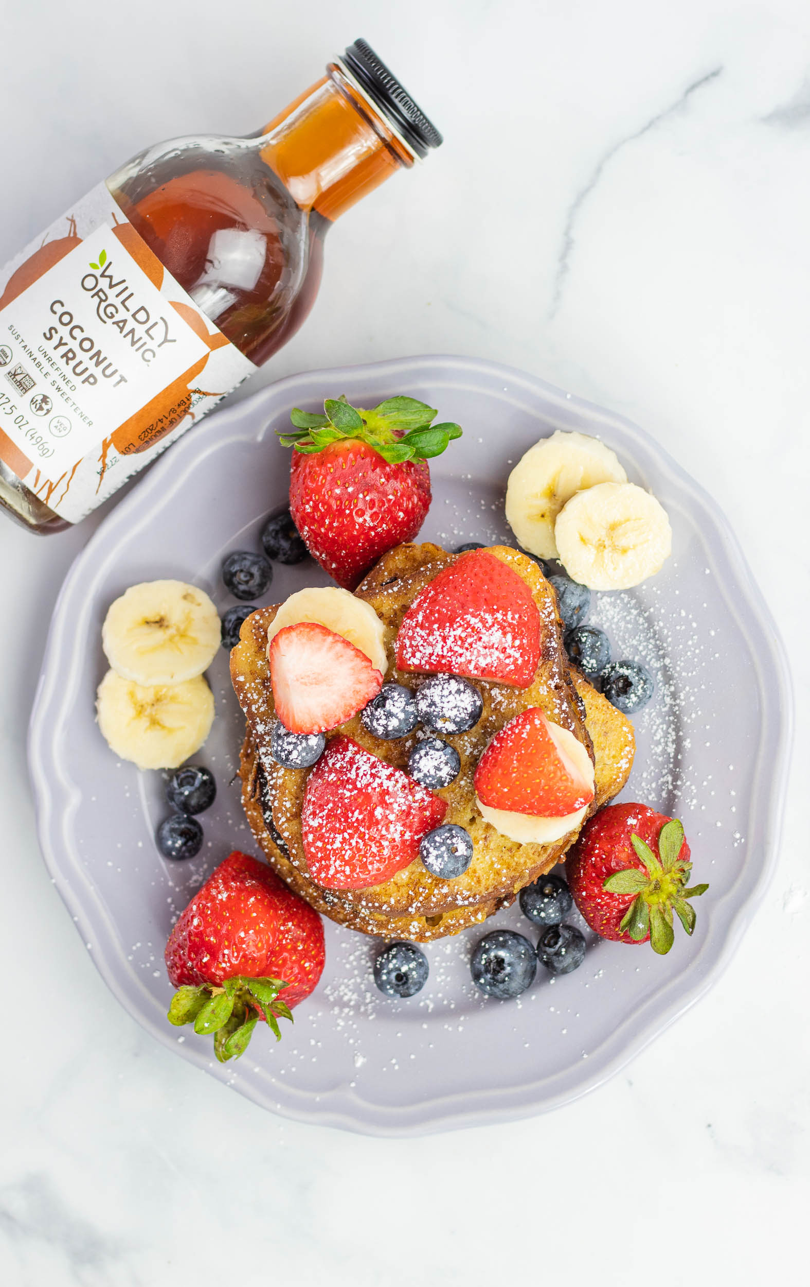 French toast on a plate covered with fresh fruit