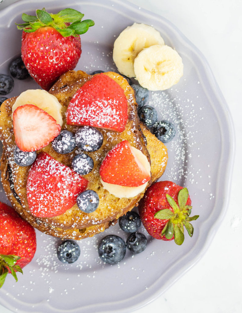French toast on a plate covered with fresh fruit