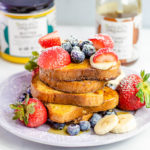 French toast on a plate covered with fresh fruit
