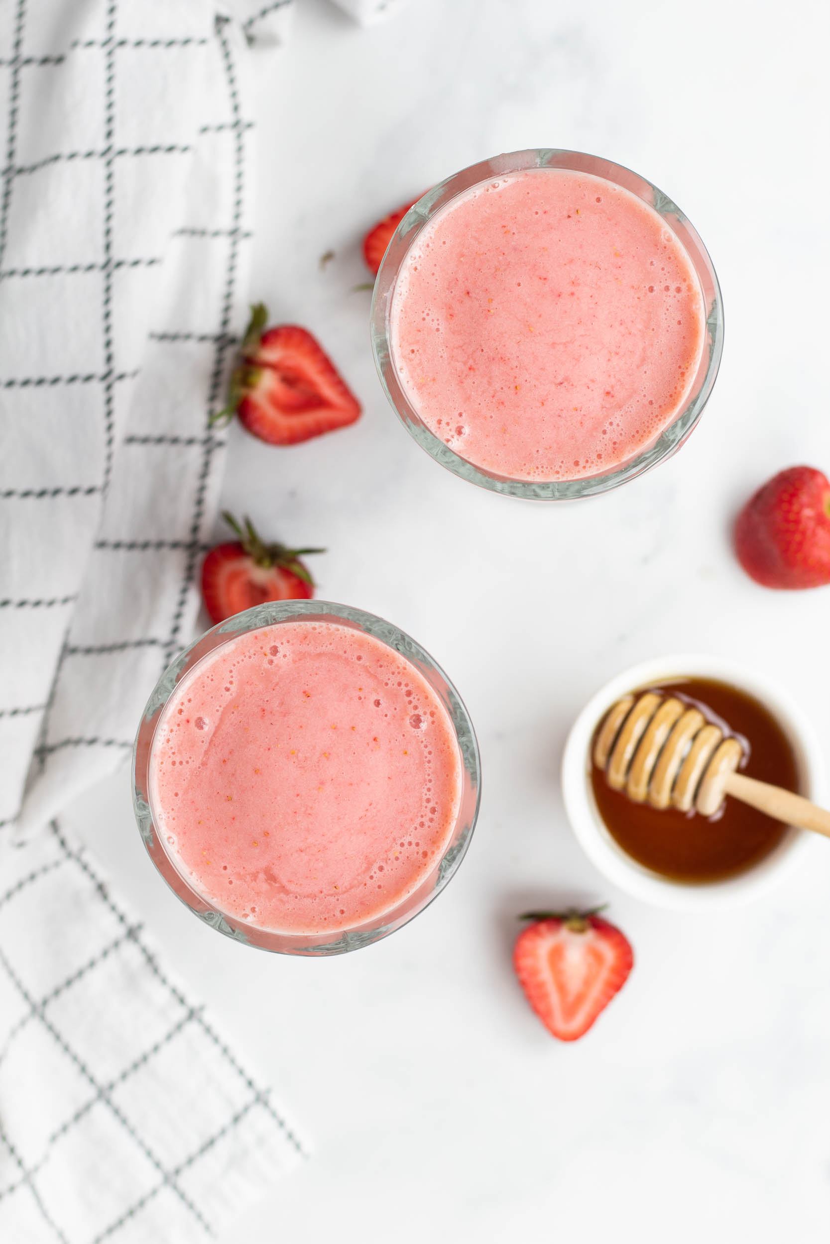 Strawberry smoothie in two glasses with straws